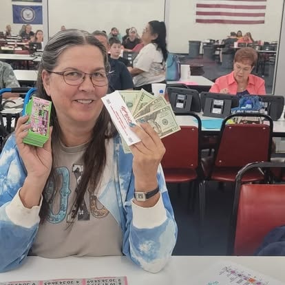 Woman holding play money in a classroom setting