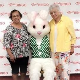 Two women posing with Easter Bunny mascot
